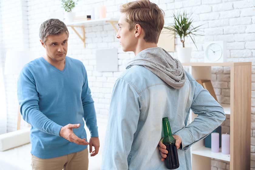 Father and Teenage Son Arguing Over Beer Bottle